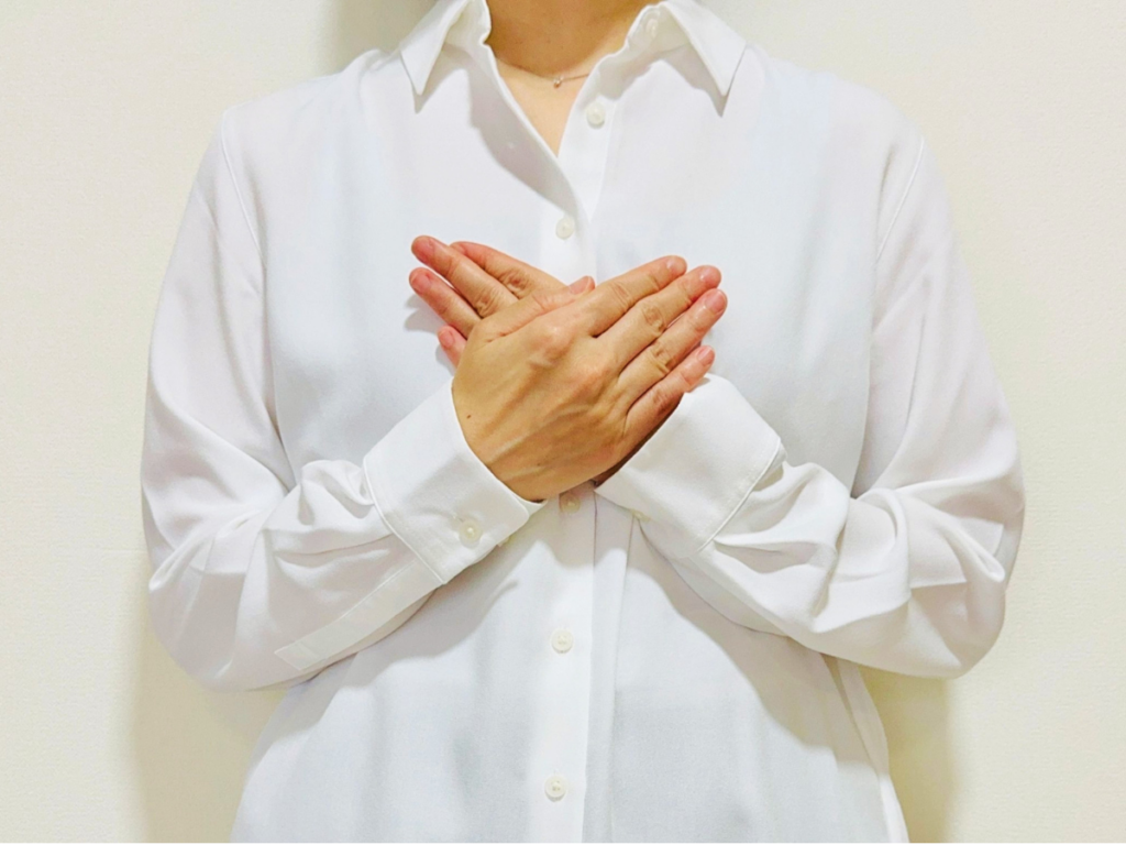 両手を胸に当てる女性